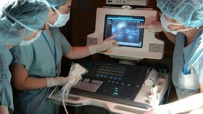 A medical team performs an ultrasound procedure.